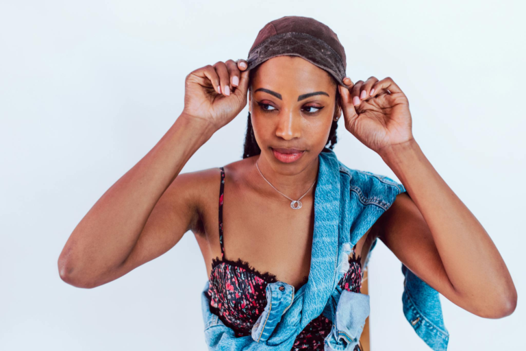 A young woman adjusts her wig with style, showcasing confidence and fashion.